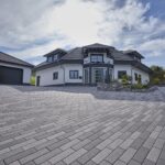 Nimbus Pflasterstein Mittelgrau in moderner Hofeinfahrt, schlankes Format