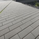 Nimbus Pflasterstein Hellgrau in moderner Hofeinfahrt, schlankes Format