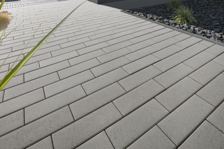 Nimbus Pflasterstein Hellgrau in moderner Hofeinfahrt, schlankes Format