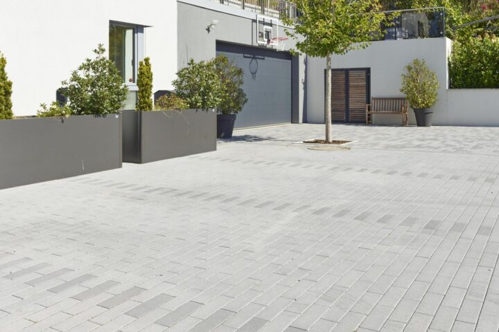 Nimbus Pflasterstein Dunkelgrau in moderner Hofeinfahrt, schlankes Format